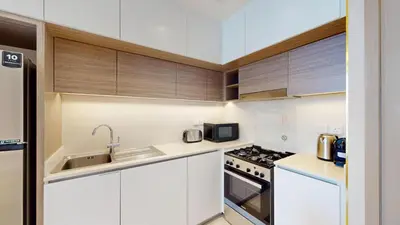 a kitchen with white cabinets and a sink at Vacationer l Stunning 1 Bedroom l City View l Pool, Gym Access in Dubai