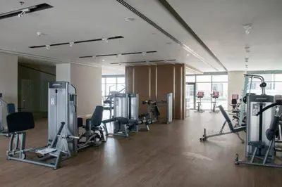 a gym with several treadmills and machines in a room at Vacationer l Stunning 1 Bedroom l City View l Pool, Gym Access in Dubai