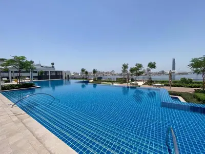 a large swimming pool in a resort with blue water at Vacationer l Stunning 1 Bedroom l City View l Pool, Gym Access in Dubai
