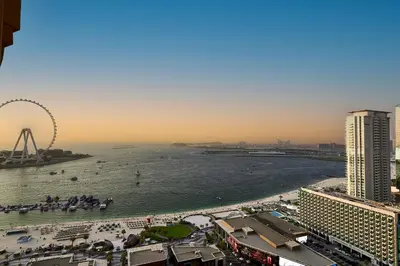 a view of a beach with a ferris wheel in the water at Full Ocean & Palm Views Apartments in JBR Beachfront with Dubai Eye Views in Dubai