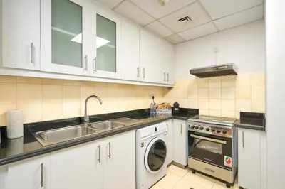 a kitchen with white cabinets and a sink and a dishwasher at Full Ocean & Palm Views Apartments in JBR Beachfront with Dubai Eye Views in Dubai