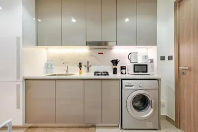 a kitchen with a washing machine and a microwave at Ramaira Homes Azizi Riviera 26 by Vacay Xeal in Dubai