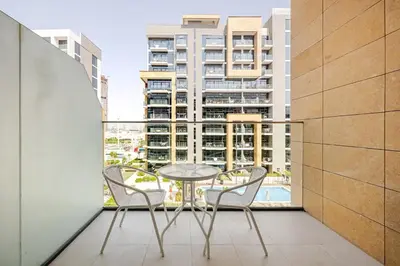 a table and chairs on a balcony with a view of a building at Ramaira Homes Azizi Riviera 26 by Vacay Xeal in Dubai