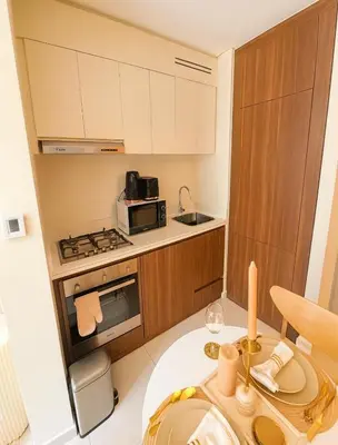 a small kitchen with a table and a microwave at Modern 1BR Near Burj Khalifa Business Bay Reva Apt in Dubai