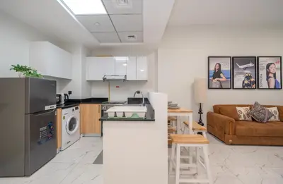 a kitchen and a living room with a couch at Stylish 1BR Just 3 Minutes Walk to Metro in Dubai