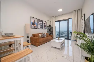 a living room with a couch and a table at Stylish 1BR Just 3 Minutes Walk to Metro in Dubai