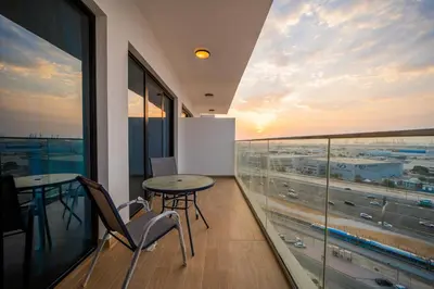a balcony with a table and chairs in a building at Stylish 1BR Just 3 Minutes Walk to Metro in Dubai