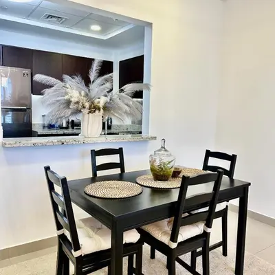 a dining room with a black table and chairs at Bellevue Towers Luxurious Burj Khalifa, Full Downtown & Old-town Views in Dubai