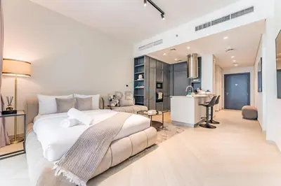 a bedroom with a large white bed and a kitchen at Studio Near Ras Al Khor Wildlife Sanctuary with Partial Creek Views, Just Minutes from Downtown Attractions, Wilton Park Residences, Sobha Hartland by Deluxe Holiday Homes in Dubai