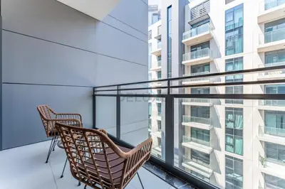 two chairs on the balcony of a building at Studio Near Ras Al Khor Wildlife Sanctuary with Partial Creek Views, Just Minutes from Downtown Attractions, Wilton Park Residences, Sobha Hartland by Deluxe Holiday Homes in Dubai