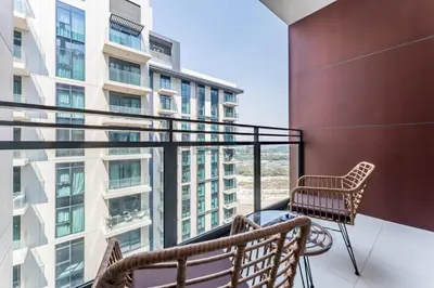 a balcony with two chairs and a table at Studio Near Ras Al Khor Wildlife Sanctuary with Partial Creek Views, Just Minutes from Downtown Attractions, Wilton Park Residences, Sobha Hartland by Deluxe Holiday Homes in Dubai