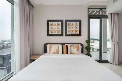 a bedroom with a white bed and a large window at Elegant 3BR & City Skyline View Azizi Greenfield in Dubai