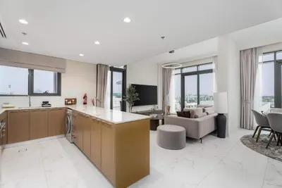 a large kitchen and living room with a couch at Elegant 3BR & City Skyline View Azizi Greenfield in Dubai