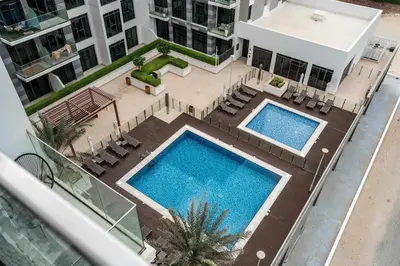 an overhead view of two swimming pools in a building at Elegant 3BR & City Skyline View Azizi Greenfield in Dubai