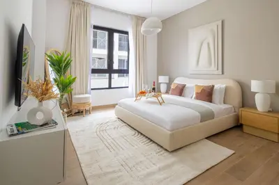 a white bedroom with a large bed and a tv at Frank Porter - La Sirene, Jumeirah in Dubai