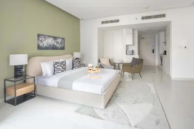 a bedroom with a large bed and a living room at Frank Porter - The Vogue, Business Bay in Dubai