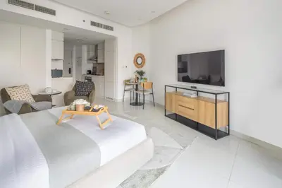 a living room with a bed and a tv at Frank Porter - The Vogue, Business Bay in Dubai