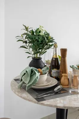 a table with a plate and a potted plant on it at Frank Porter - The Vogue, Business Bay in Dubai