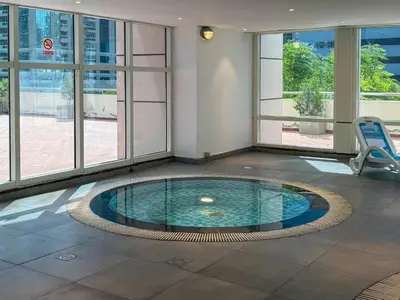 a pool in the middle of a room with windows at Frank Porter - Dubai Arch Tower , JLT in Dubai