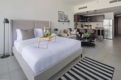 a bedroom with a large bed and a living room at Frank Porter - Dubai Arch Tower , JLT in Dubai