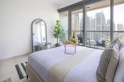 a bedroom with a large bed and a large window at Frank Porter - Dubai Arch Tower , JLT in Dubai