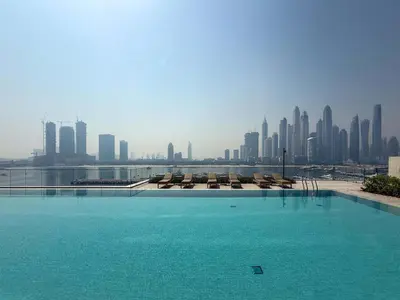 a swimming pool with a city skyline in the background at Frank Porter - Palace Beach Residence Tower 1 in Dubai