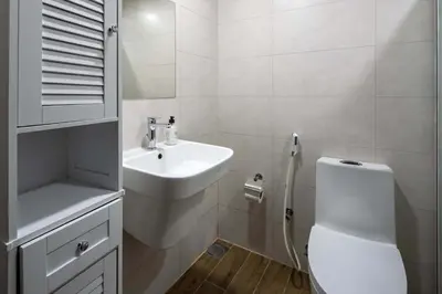 a white bathroom with a toilet and a sink at Frank Porter - Hera Tower in Dubai