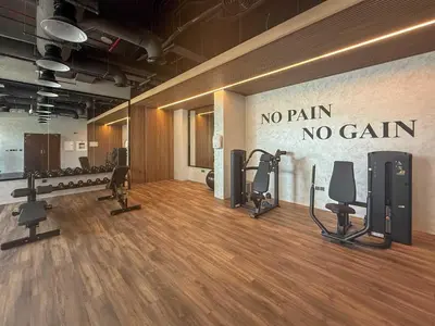 a gym with dumbbells and exercise equipment on the wall at Frank Porter - Elysee III by Pantheon, JVC in Dubai