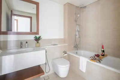 a bathroom with a tub and a toilet and a sink at Frank Porter - Palace Beach Residence Tower 2 in Dubai