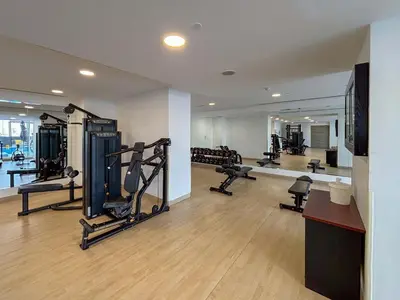a gym with several treadmills and machines in a room at Frank Porter - Bloom Heights Tower B in Dubai