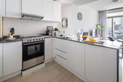 a kitchen with white cabinets and a stove top oven at Frank Porter - Bloom Heights Tower B in Dubai