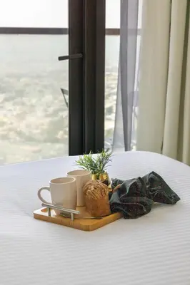 a tray with cups and plants on a bed at Frank Porter - Aykon City Tower C in Dubai
