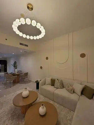 a living room with a couch and tables and a chandelier at Duja Tower in Dubai