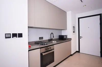 a kitchen with a sink and a stove top oven at Cozy Studio, All Bills Included in Dubai