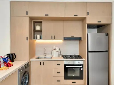 a kitchen with a white refrigerator and a sink at Elegant 2BR Apartment in Socio Tower - Dubai Hills in Dubai