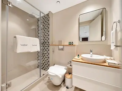 a bathroom with a toilet and a sink and a shower at Elegant 2BR Apartment in Socio Tower - Dubai Hills in Dubai