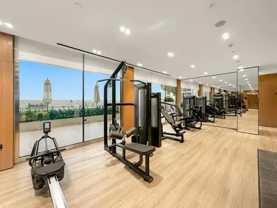 a gym with cardio equipment and a large window at FIRST CLASS Studio Cozy Hideaway in Dubai
