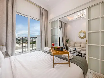 a bedroom with a bed and a living room at Livin' Holidays - 1 BR - Next to Miracle garden in Dubai