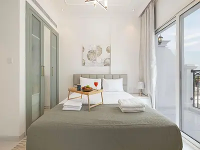 a bedroom with a large bed and a table at Livin' Holidays - 1 BR - Next to Miracle garden in Dubai