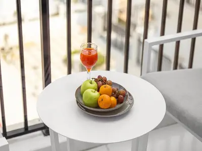 a bowl of fruit on a table with a drink at Livin' Holidays - 1 BR - Next to Miracle garden in Dubai