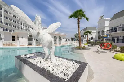 a statue of a horse standing next to a swimming pool at Livin' Holidays - 1 BR - Next to Miracle garden in Dubai