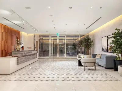 a lobby with a couch and a table and chairs at Spacious 1BR for 2, 10 Min Meydan Racecourse, Pool & Gym Access in Dubai