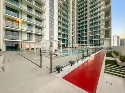 a large apartment building with a pool in front of it at FIRST CLASS Studio Cozy Luxury Escape in Dubai