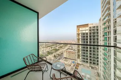 a balcony with chairs and a table and a large window at FIRST CLASS Studio Cozy Luxury Escape in Dubai
