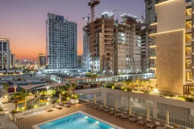 a view of a city at night with a swimming pool at FIRST CLASS Studio Luxury Comfort , Pool View in Dubai