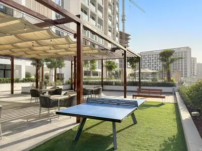 a ping pong table on a patio with tables and chairs at FIRST CLASS Studio Luxury Comfort , Pool View in Dubai