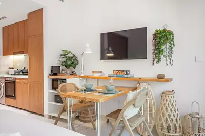 a kitchen with a table and chairs and a tv at FIRST CLASS Studio Luxury Comfort , Pool View in Dubai