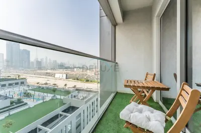 a balcony with two chairs and a table on a building at Modern Apartment Near Sobha Hartland Amenities, Minutes from Ras Al Khor Wildlife Sanctuary and Downtown Dubai, Sobha Creek Vistas Tower A, Sobha Hartland by Deluxe Holiday Homes in Dubai