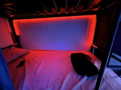 a bed in a room with a red light at mixed room jumeirah 1, bed hostel dubai in Dubai