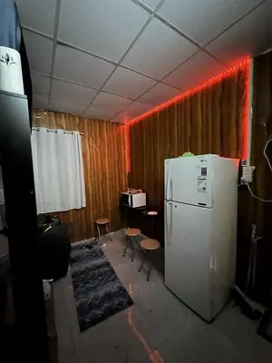 a room with a white refrigerator and a table and a desk at mixed room jumeirah 1, bed hostel dubai in Dubai